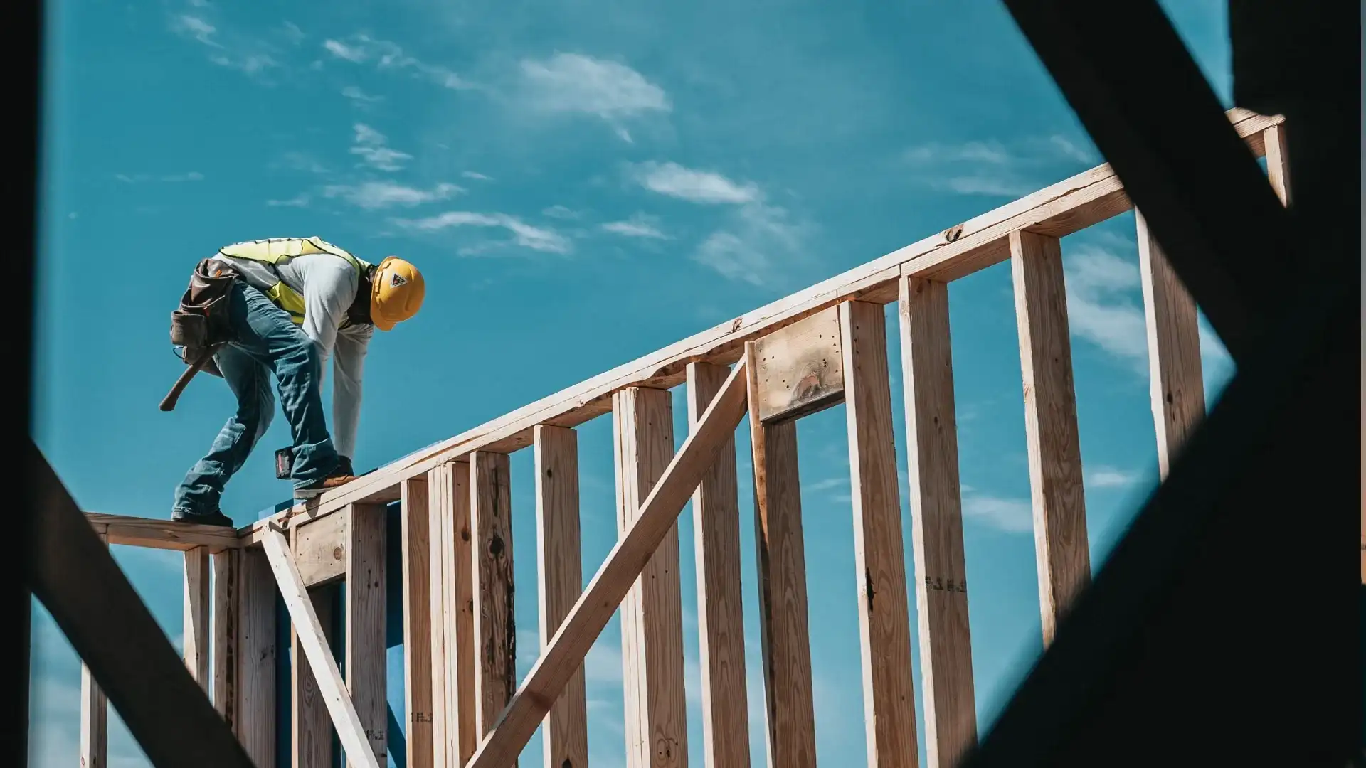 Framer working on top of a wood wall frame